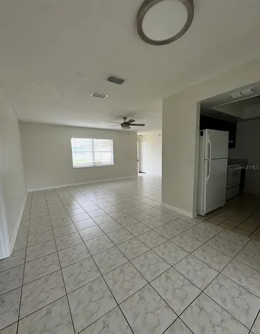 an empty room and chandelier fan