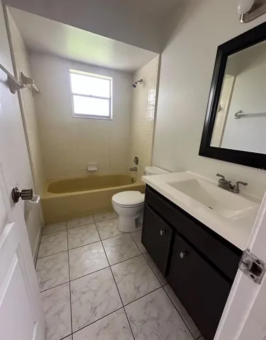 a bathroom with a sink a toilet a mirror and shower