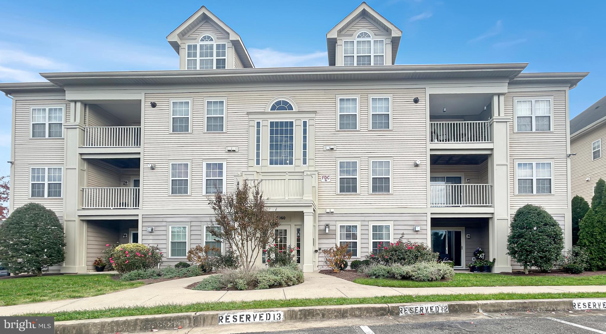 a view of a brick house with lots of windows and plants