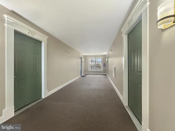 a view of a hallway with wooden floor and a living room