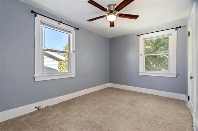an empty room with a window and a fan