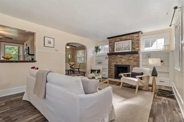 a living room with furniture a large window and a fireplace