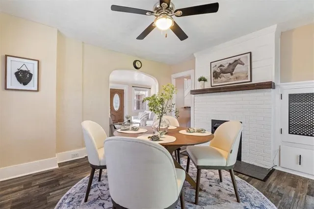 a dining room with furniture a fireplace and wooden floor