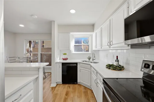 a kitchen with stainless steel appliances a sink dishwasher stove refrigerator and cabinets