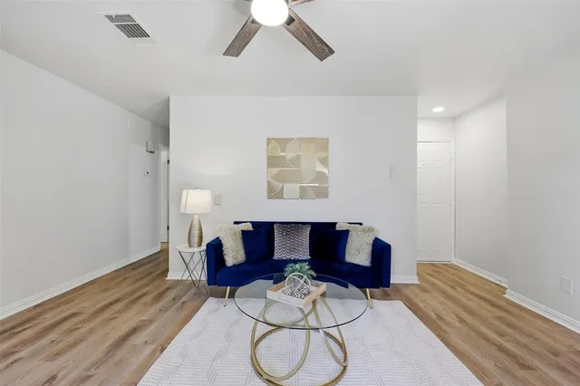 a living room with furniture and a wooden floor