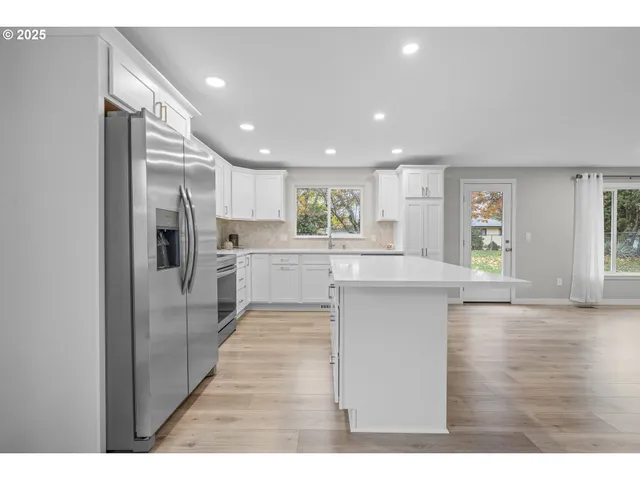 a open kitchen with stainless steel appliances granite countertop a refrigerator and a sink