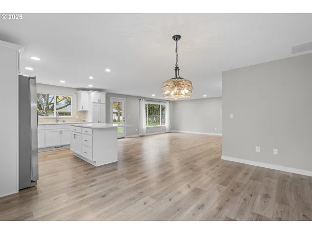 a view of a kitchen with a sink dishwasher a refrigerator cabinets and wooden floor