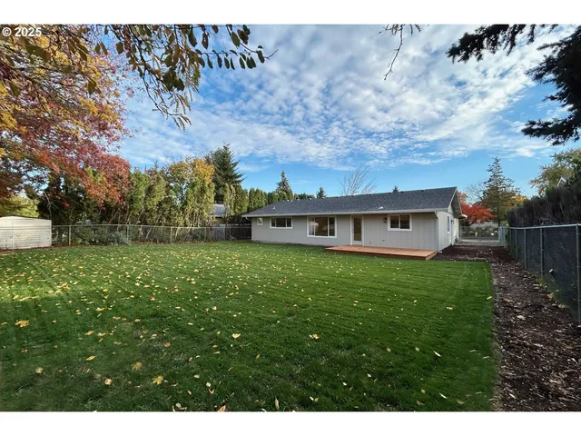 a view of a house with a big yard potted plants and large tree