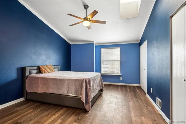 a bed sitting in a spacious bedroom next to a window