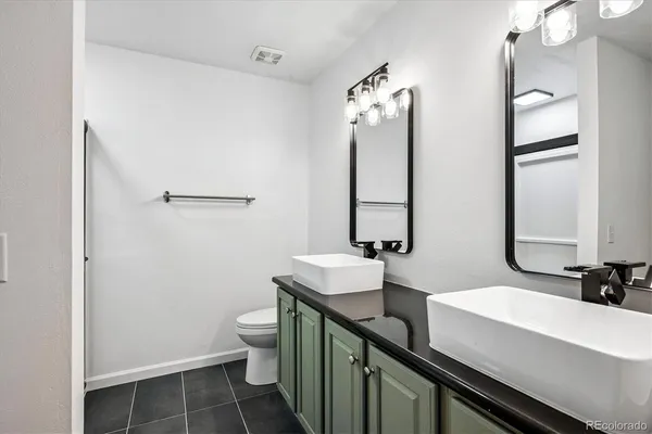 a bathroom with a double vanity sink mirror and toilet