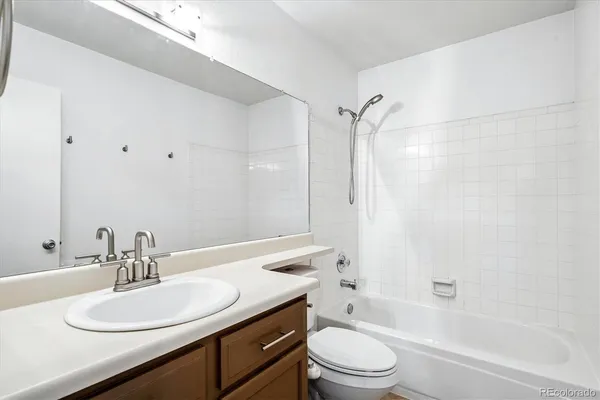 a bathroom with a granite countertop sink toilet a mirror and shower