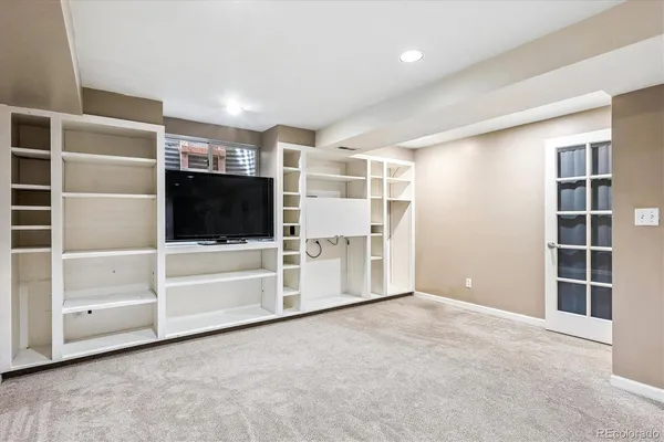 a view of an empty room with a fireplace and windows