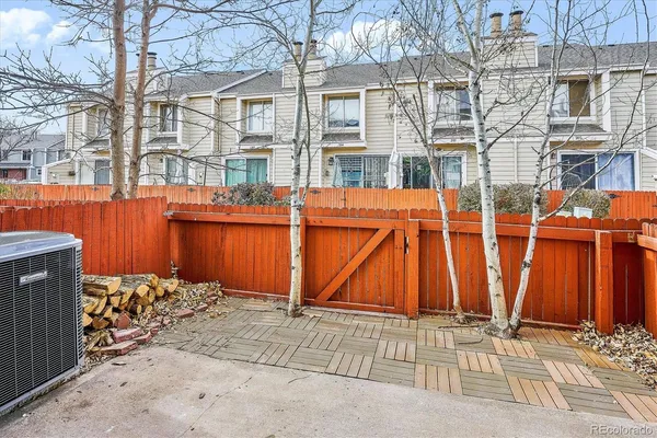 a view of a backyard with a barbeque and wooden fence