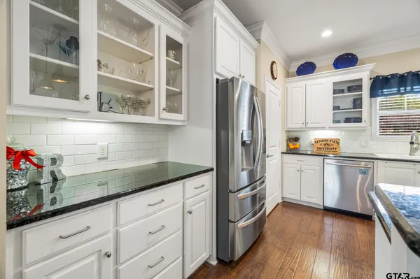a kitchen with granite countertop white cabinets and white appliances