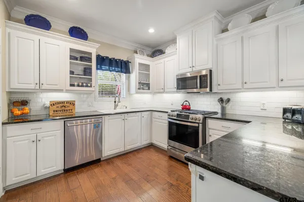 a kitchen with stainless steel appliances granite countertop a stove sink and cabinets