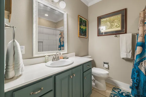 a bathroom with a granite countertop sink mirror vanity and toilet