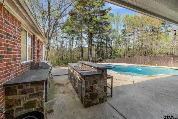 a view of a house with swimming pool next to a yard