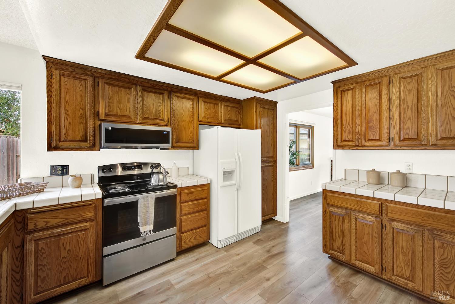 2219 Channing Court Fairfield, CA 94533 - Photo 25 of 81 a kitchen with stainless steel appliances granite countertop a stove a sink dishwasher and a refrigerator with wooden cabinets