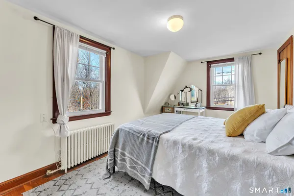 a bedroom with 2 bed and a window