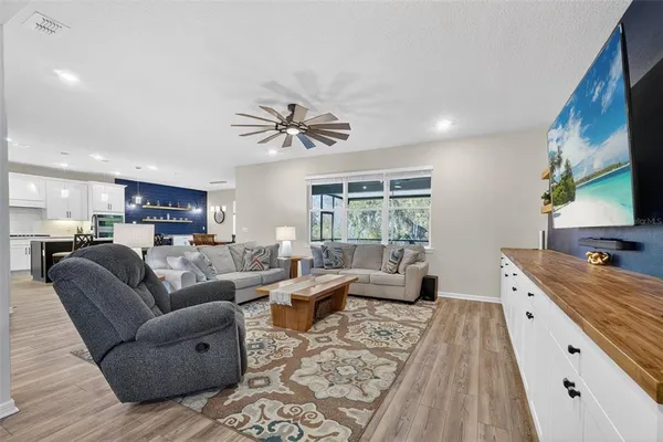 a kitchen with stainless steel appliances a dining table chairs and wooden floor