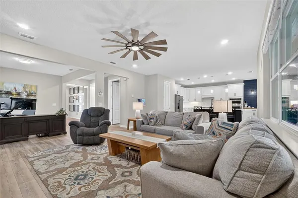 a kitchen with stainless steel appliances granite countertop a table chairs sink refrigerator and cabinets
