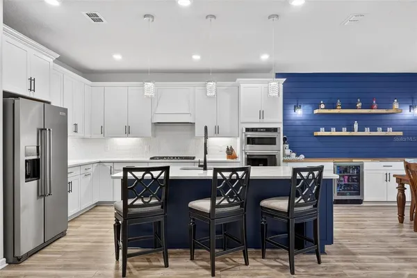 a large kitchen with kitchen island a dining table and chairs