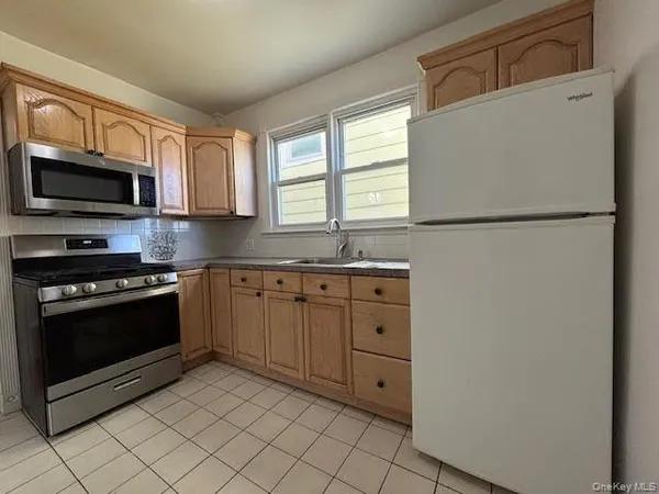 a kitchen with cabinets stainless steel appliances and window