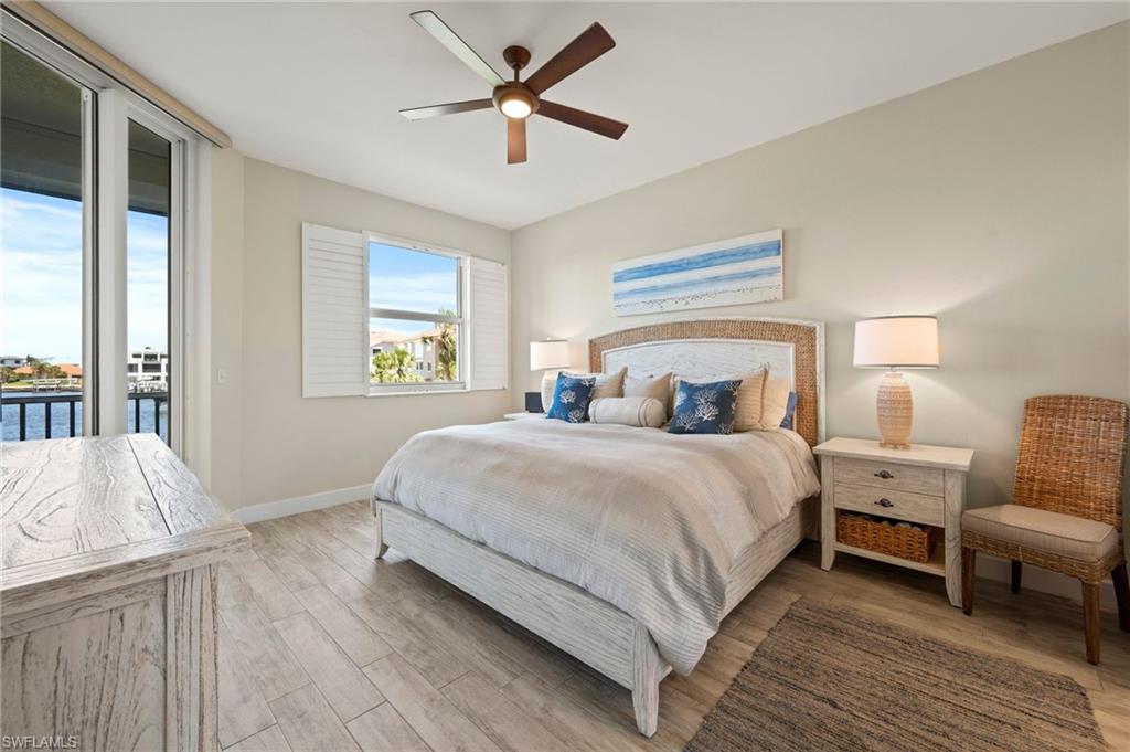 450 Launch Circle, Unit 201 Naples, FL 34108 - Photo 13 of 43 a bedroom with a bed and wooden floor