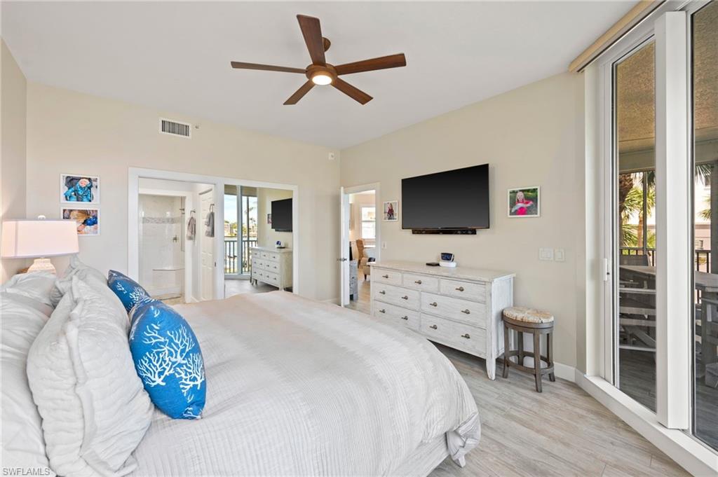 450 Launch Circle, Unit 201 Naples, FL 34108 - Photo 15 of 43 a bedroom with a bed and a flat screen tv