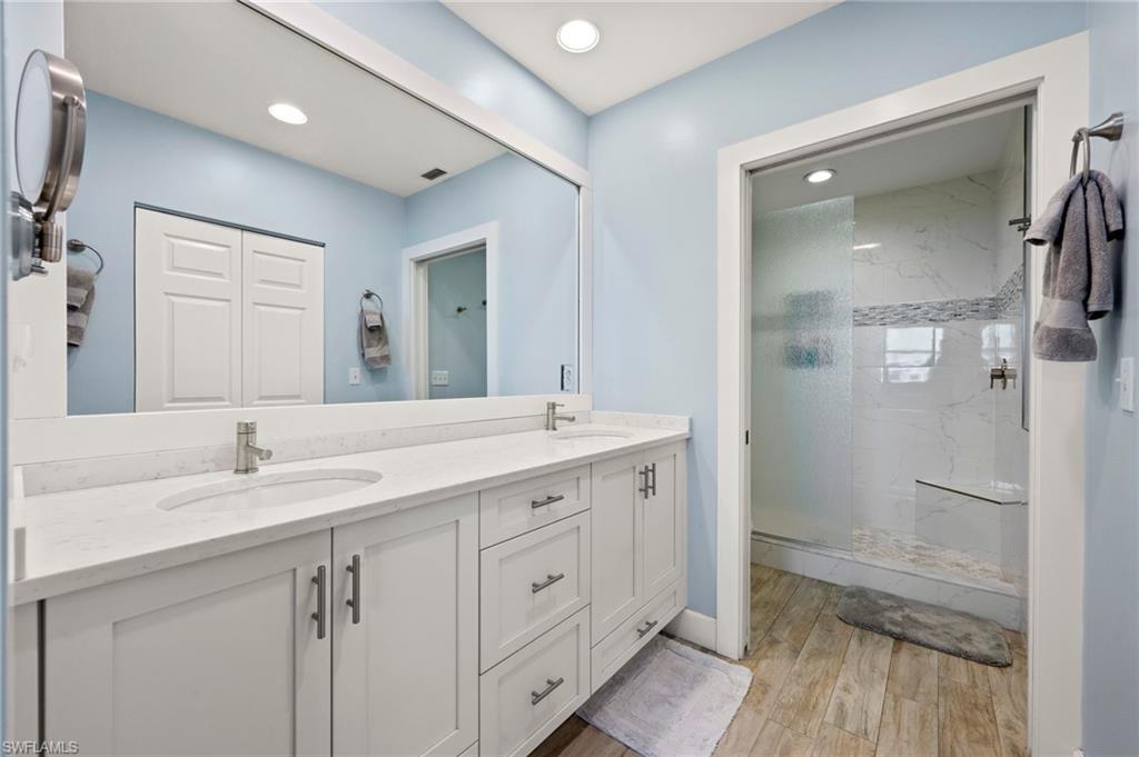 450 Launch Circle, Unit 201 Naples, FL 34108 - Photo 16 of 43 a spacious bathroom with a shower a sink and a mirror