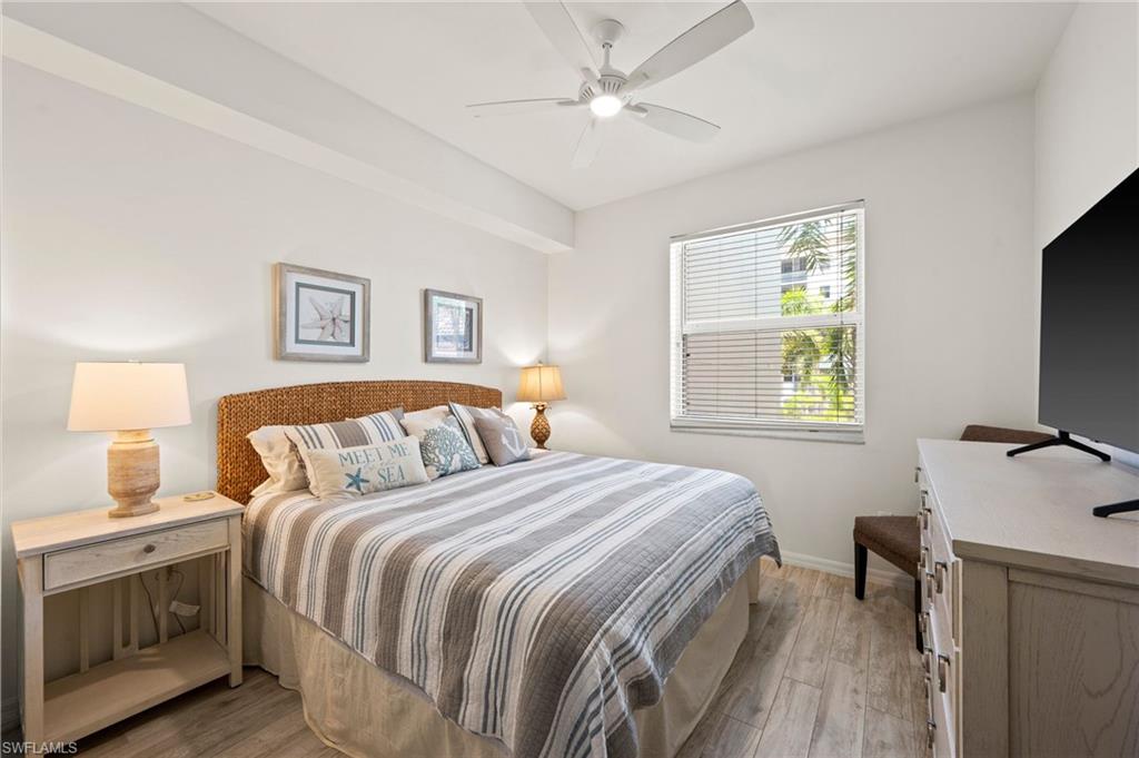 450 Launch Circle, Unit 201 Naples, FL 34108 - Photo 18 of 43 a bedroom with a bed and a flat screen tv