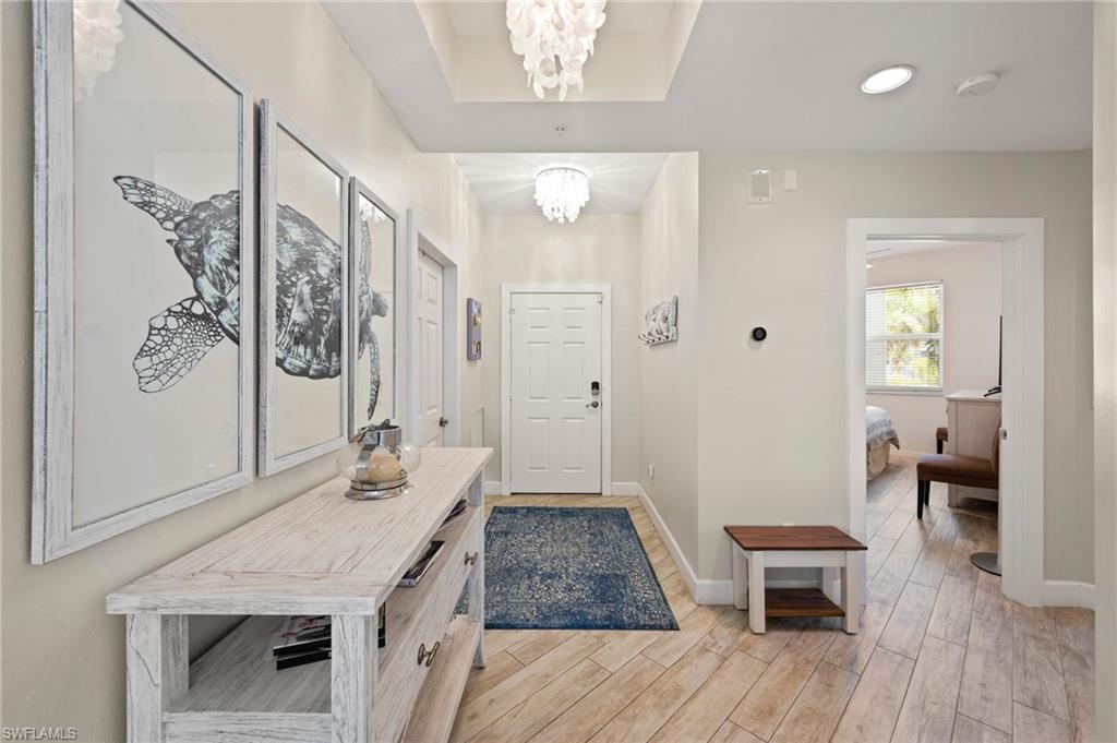 450 Launch Circle, Unit 201 Naples, FL 34108 - Photo 23 of 43 a bathroom with a granite countertop sink a toilet a mirror and vanity