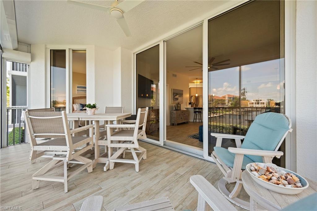 450 Launch Circle, Unit 201 Naples, FL 34108 - Photo 24 of 43 a dining room with furniture a chandelier and wooden floor