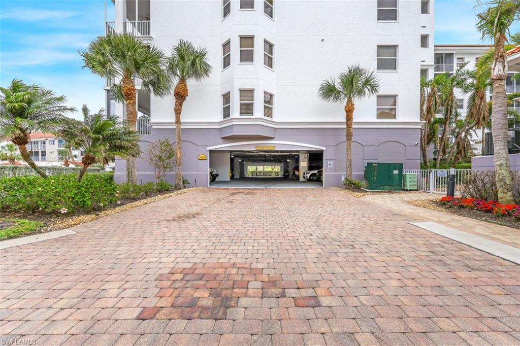 450 Launch Circle, Unit 201 Naples, FL 34108 - Photo 28 of 43 a front view of a house with a yard and a garage
