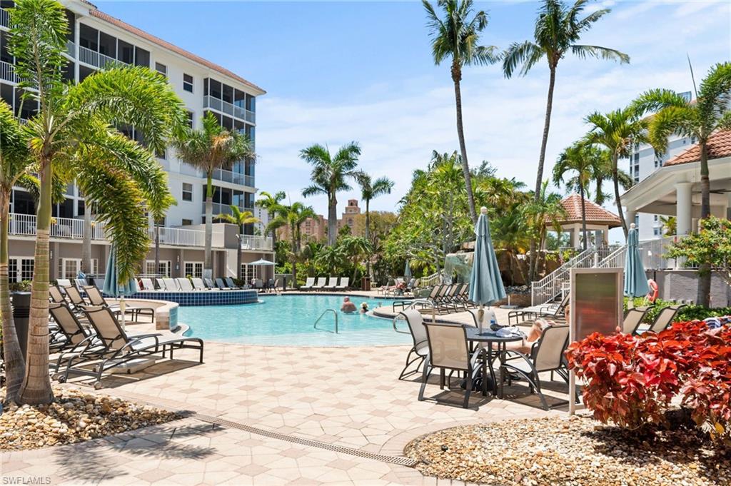 450 Launch Circle, Unit 201 Naples, FL 34108 - Photo 29 of 43 a view of a patio with a table and chairs and potted plants
