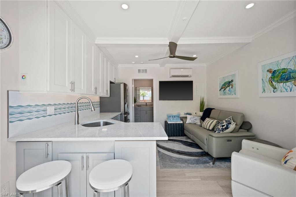 450 Launch Circle, Unit 201 Naples, FL 34108 - Photo 36 of 43 a living room with furniture and a fireplace