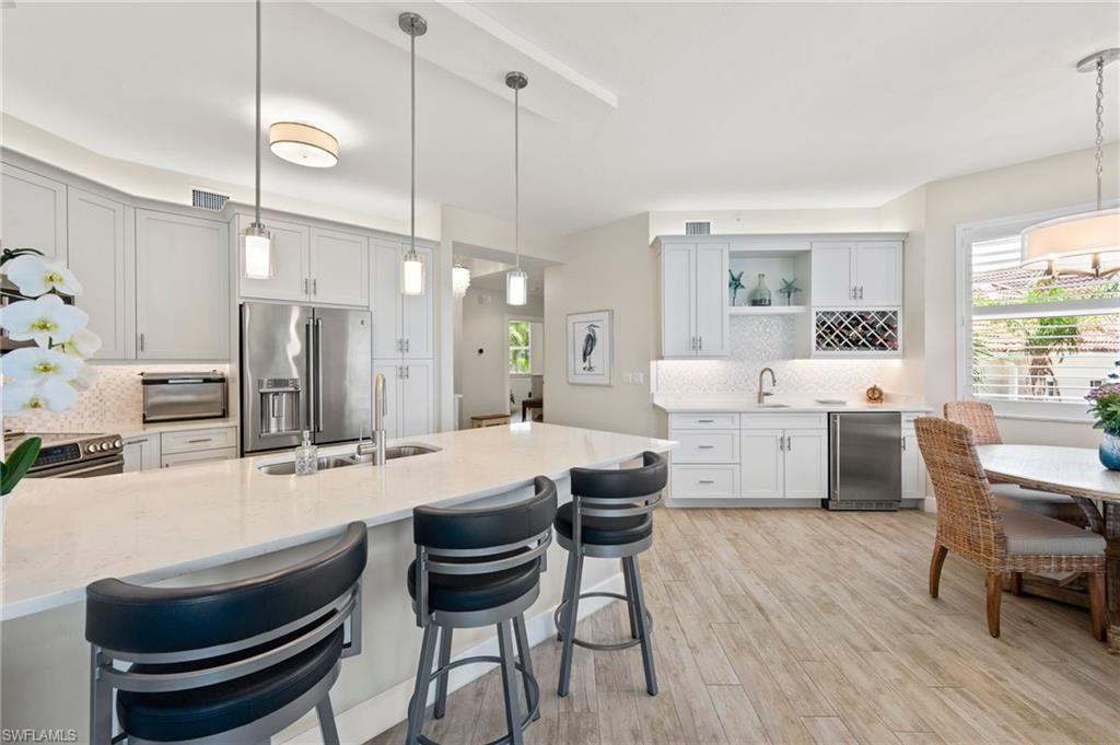 450 Launch Circle, Unit 201 Naples, FL 34108 - Photo 6 of 43 a large kitchen with a table and chairs