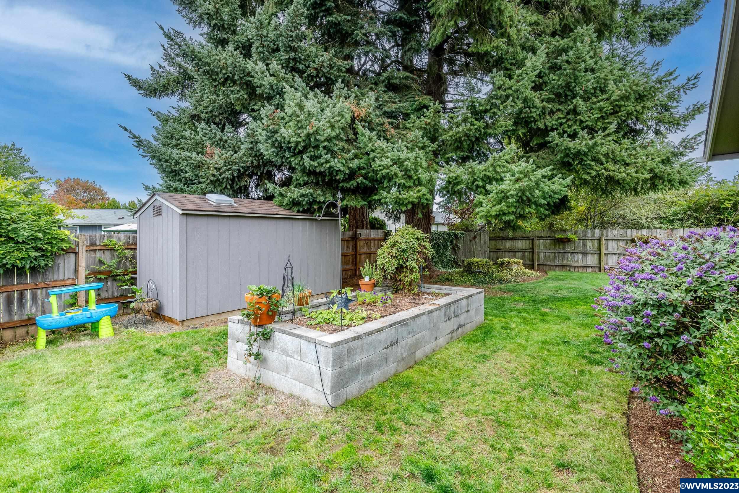 2136 15th Street Springfield, OR 97477 - Photo 37 of 38 a backyard of a house with table and chairs plants and large tree