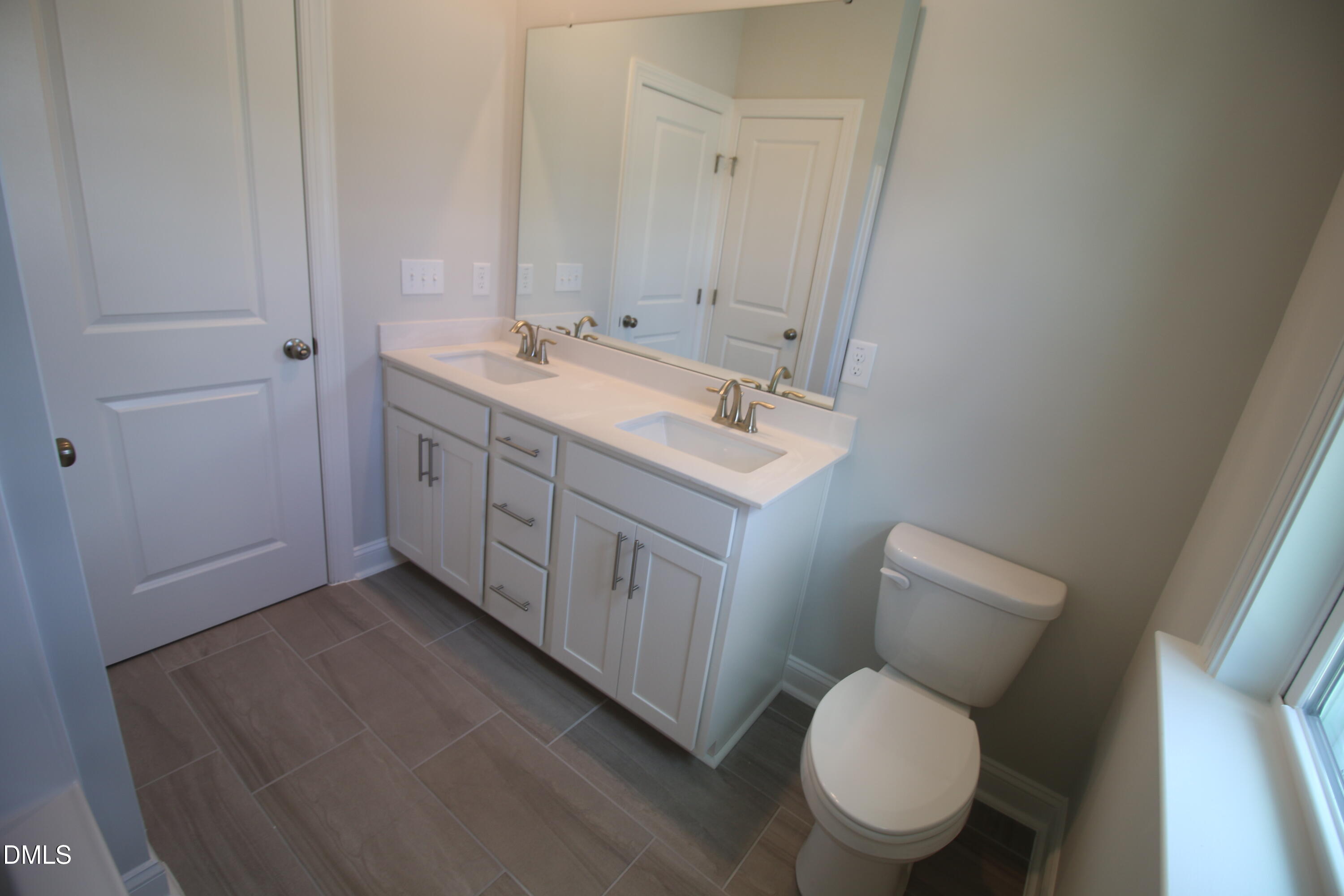 1201 Cosmic Drive Durham, NC 27703 - Photo 34 of 51 a bathroom with a toilet sink a mirror and vanity