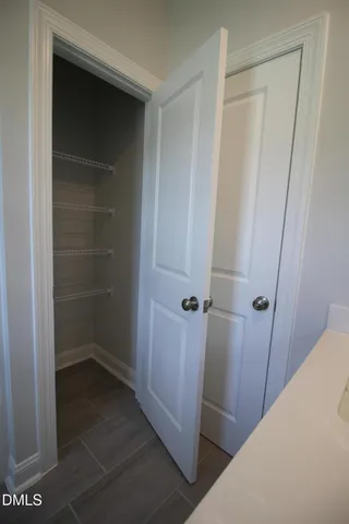 a view of an empty room with wooden floor and closet