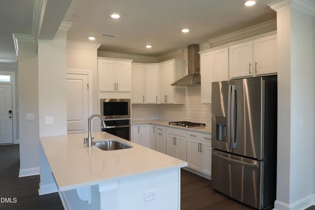 an aerial view of residential houses with outdoor space and lake view