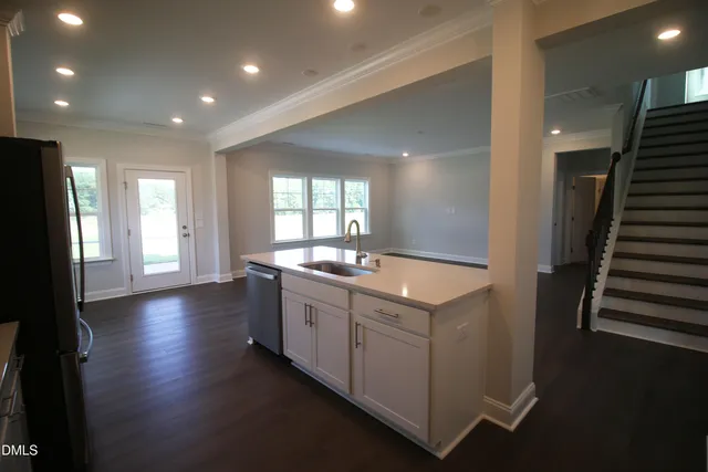 a kitchen with stainless steel appliances granite countertop a refrigerator a stove a sink and a microwave