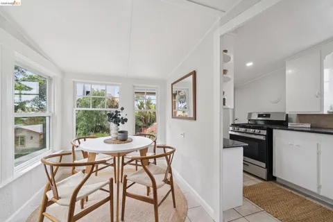 a kitchen with a table chairs and large window