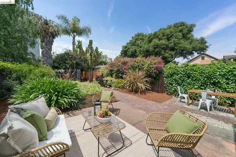 a view of a patio with couches table and chairs and potted plants