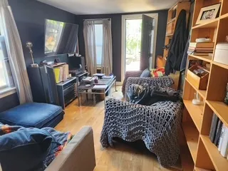 a living room with furniture a lamp and large window