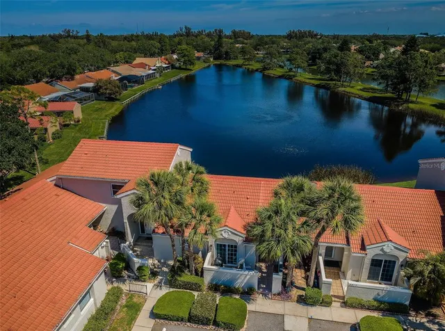 a front view of a house with a garden and trees