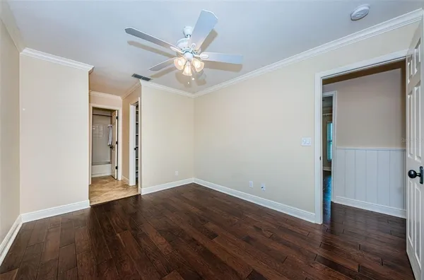 a view of an empty room with a window and wooden floor