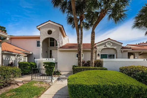 a kitchen with stainless steel appliances granite countertop a refrigerator a stove and a sink with wooden floor