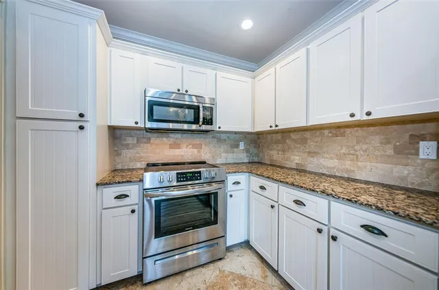 a kitchen with granite countertop a sink and a stove