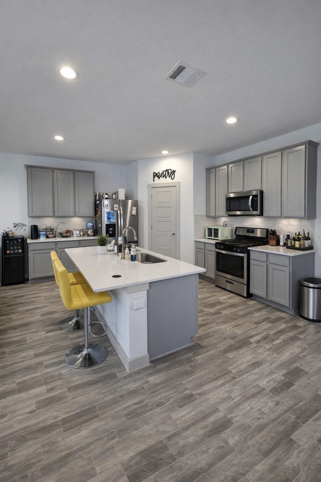 7722 Caspian Ranch Drive Rosharon, TX 77583 - Photo 3 of 15 a kitchen with stainless steel appliances granite countertop a sink dishwasher a stove a refrigerator cabinets and a dining table with wooden floor